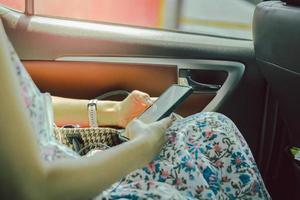 Casual woman in taxi car using smartphone. photo