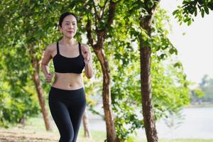 mujer corriendo afuera en el parque en un hermoso verano. foto