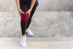 las mujeres tienen dolor de rodilla mientras hacen ejercicio al subir las escaleras. foto