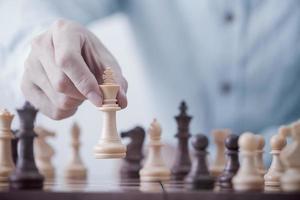 el hombre de negocios juega con el juego de ajedrez en el juego de éxito de la competencia, la estrategia conceptual y la gestión o el liderazgo exitosos foto