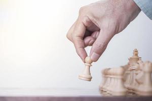 el hombre de negocios juega con el juego de ajedrez en el juego de éxito de la competencia, la estrategia conceptual y la gestión o el liderazgo exitosos foto
