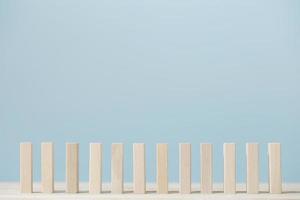 Domino block isolated pieces standing in a row on blue background. photo