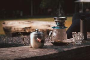 la cafetera se coloca encima de una silla de madera en la zona de acampada. foto