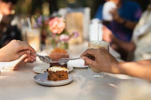 Hand with spoon getting ready to taste homemade carrot cake in a cafe. photo