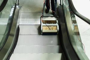 escalera mecánica de limpieza de limpiador masculino con máquina en edificio moderno. foto