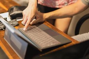 Asian couple working on laptop with hand pointing at screen. photo