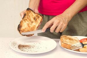 resuelva el problema de la quema de tostadas y hágala comestible usando un cuchillo para raspar la quemadura, consejos de cocina foto