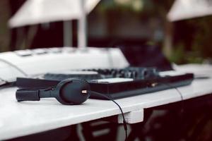 Black headphones and professional mixing console on table. photo