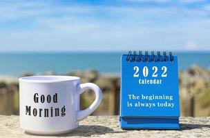 Motivational and Inspirational quote on blue standing notepad and coffee cup photo