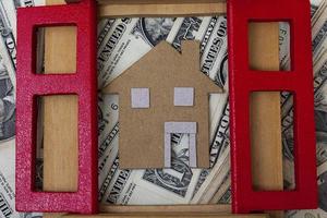 Brown paper house model with window frame on dollar banknotes photo