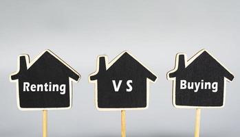 alquilar vs comprar texto en casa de madera. concepto de inversión inmobiliaria. foto
