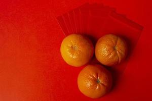 concepto de año nuevo chino - mandarinas y paquete rojo foto
