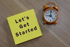 Lets get started - message with advice on yellow notepad with alarm clock photo