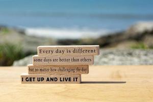 Motivational and inspirational quote on wooden block with blurred background of ocean photo