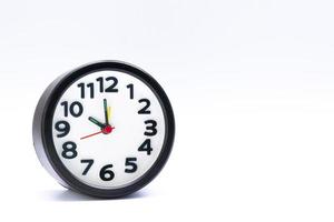 Black alarm clock isolated on white background. The clock set at 10 o'clock. photo