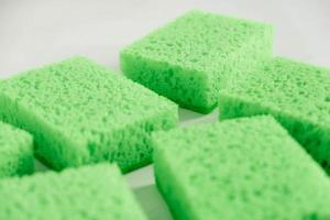 Green sponges for cleaning on a white background photo