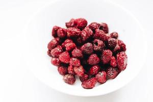 Fresh raspberries in a white plate on white background. Close up photo