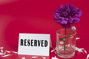 A tag of reservation placed on the table with red background. photo