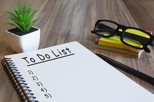 Text on notepad with stationery on wooden desk - To do list photo