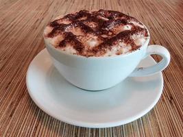 Coffee in white cup on wooden table in cafe. Copy space. photo