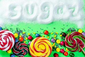 Different sweets on a green background with the inscription Sugar photo
