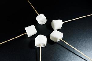 Marshmallows on sticks pointing to the center