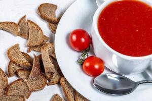 Tomato soup in a tureen with slices of black bread and tomatoesjpg