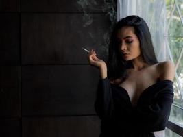 Asian women in lingerie are smoking in the house