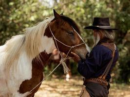 Cowboy touches the horse with love photo