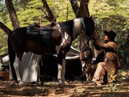 los vaqueros occidentales tocan a los caballos con amor debido a las relaciones amistosas que comparten el sufrimiento y la felicidad foto