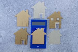 Calculator with paper house model. Home mortgage and investment concept. photo