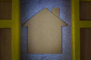 Paper house model with window frame background. Home insurance concept. photo