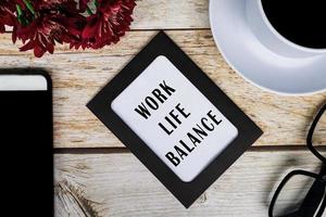 Work Life Balance text on chalkboard frame on wooden desk. Business concept. photo