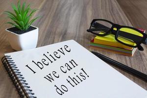 Motivational text on white notepad wooden desk. Business concept photo