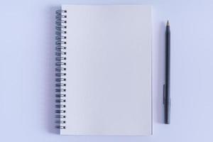 Notepad with pen on white background. Flat lay with open book page photo