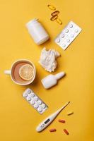 antecedentes médicos con pastillas médicas, cápsulas de vitaminas, termómetro y té de limón saludable