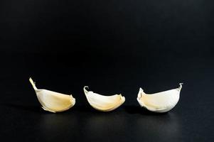 tres dientes de ajo sobre una superficie negra foto