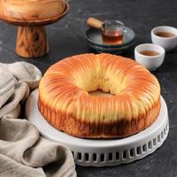 Wool Bread is Sweet Bread Dough Shaped like a Blob of Wool Thread. Filled with Chocolate and Grated Cheese. Served in White Plate, Black Table photo