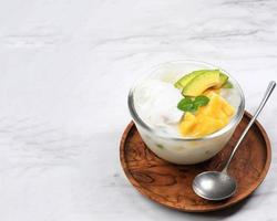 Es Teler, Traditional Indonesian Ice Dessert of Tropical Fruit Cocktail in Sweet Coconut Water and Condensed Milk Served in a Bowl photo