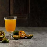 jugo de naranja tibio en un vaso, recién hecho con naranja pequeña. copiar espacio para texto o publicidad foto