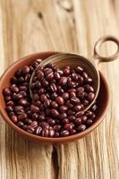 Azuki beans or red mung beans in a bowl and spoon on wooden table photo