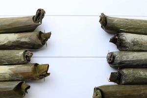 Lontong, Indonesian Compressed Rice Cake in a Form of a Cylinder Wrapped Inside a Banana Leaf. Usually Served with Sayur, Gado-Gado, or Pecel. Top View with Copy Space photo