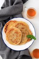 vista superior canai de oriente medio o pan plano paratha, o también conocido como roti maryam en indonesia. popular para desayunar tajil. aislado sobre fondo blanco con espacio de copia de texto foto