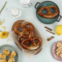 brezel bávaro de pretzel suave casero recién horneado con sal en una mesa de menta pastel. perfecto para el festival de octubre. vista superior con espacio de copia foto