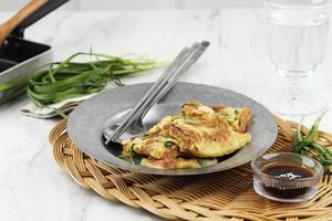 Chives Pancake, Popular as Pajeon Pancake in Korea. Made from Egg, Flour, Onion, and Chives or Green Onion Scallion. Served with Soy Suce and Sesame Seed Sprinkle