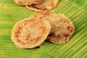 Roti Parata or Roti Canai on Banana Leaf, Susually Served with Lamb Curry or Topping with Chocolate Sprinkle and Condensed Milk photo