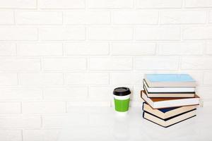 Education literature. Cup of coffee and books on the table in a class. Top view and copy space. Selective focus photo