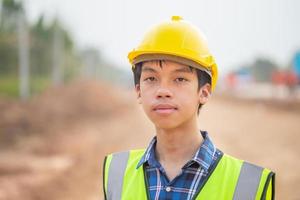 joven ingeniero en el sitio de construcción, trabajador capataz inspeccionando en el sitio de construcción de carreteras