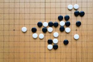 Flay Lay of Go tablero de ajedrez con piedras blancas y negras foto