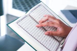 Close up of hand when reading the Holy Quran at the mosque. Selective focus